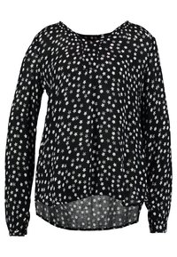 Blouse noire à manches longues avec une coupe ample, ornée d'un motif d'étoiles blanches, col rond, et un ourlet qui descend légèrement au dos.