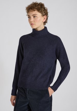 Pull-over marin en jersey avec un col haut, coupe ample, poignets et ourlet côtelés, fabriqué en matériau doux et texturé.