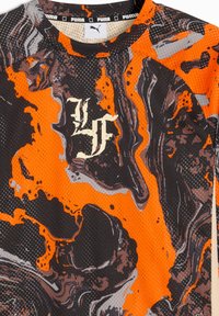Sort og orange sportskjorte med et marmor mønster, lavet af åndbart mesh-stof. Har Puma-logoet og stiliseret skrift.
