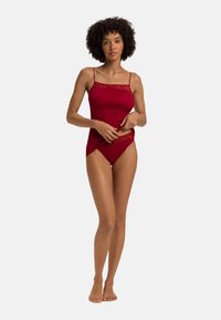 Rode bodysuit met kantafwerking, met dunne bandjes en een aansluitend ontwerp. Zachte textuur, naadloze vorm en een klassieke snit.