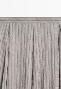 Striped fabric with a pleated texture, featuring gray and light blue lines. Soft, lightweight material with a smooth finish.