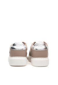 Béžové kožené tenisky s hladkou texturou, stříbrné detaily na patě, bílá gumová podešev a vyražené logo na zadní straně.