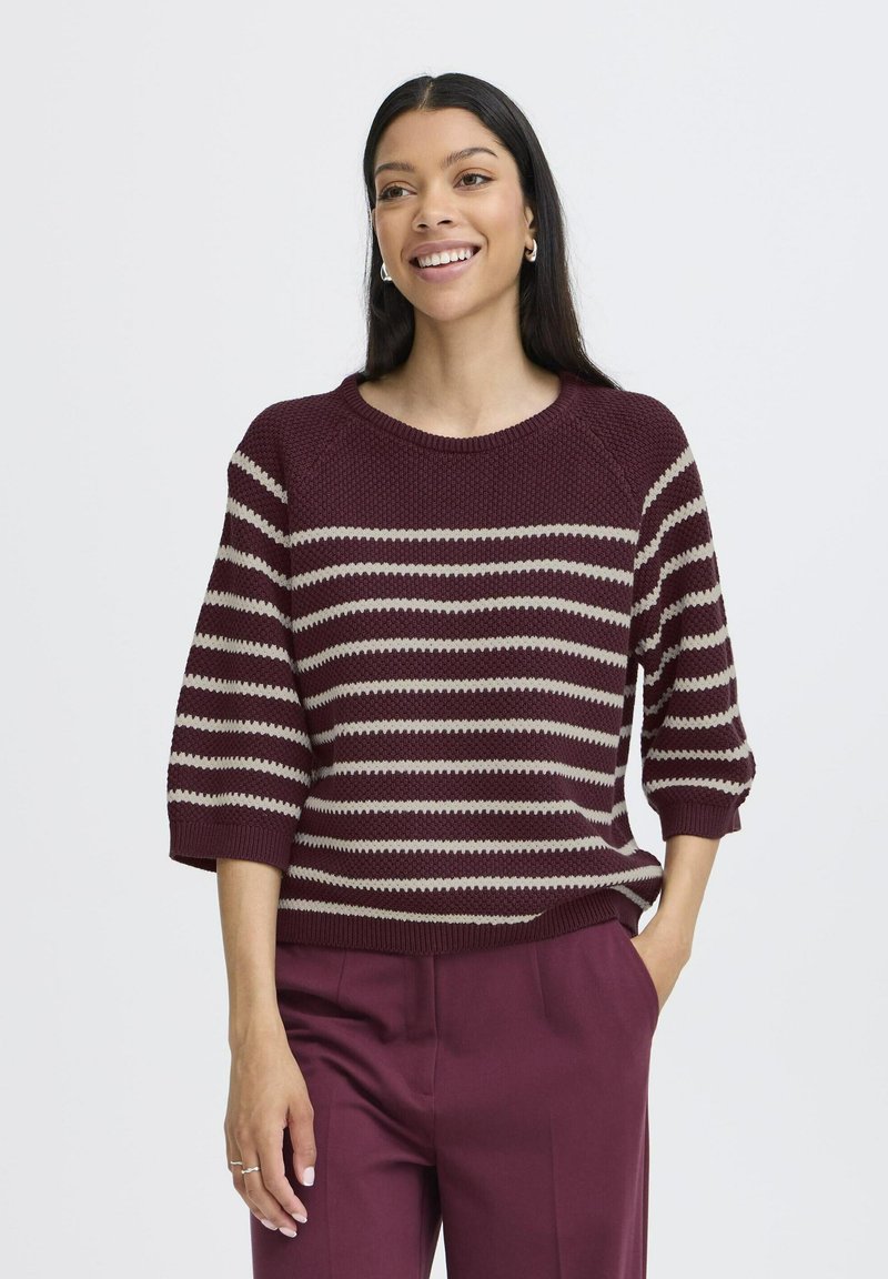 Maroon and beige striped sweater with a ribbed texture, round neck, and three-quarter sleeves, paired with plum trousers.