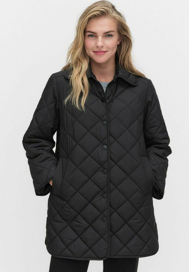 Svart vadderad jacka med skjortkrage, framknappar och långa ärmar. Tyget är slätt med en vadderad textur.