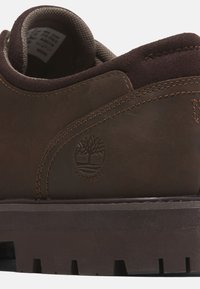 Scarpa in pelle marrone impermeabile con colletto imbottito, cuciture a contrasto, superficie testurizzata e un logo del marchio sul lato.