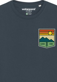 Donkerblauwe katoenen t-shirt met een grafisch ontwerp op de borst van bergen, de zon en de tekst "GOOD VIBE" in groene en warme kleuren. Ronde halsline.