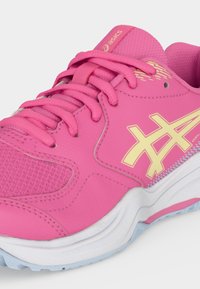 Ροζ αθλητικό παπούτσι Asics με κίτρινο λογότυπο, διάτρητη μύτη, επενδεδυμένη γλώσσα, ροζ κορδόνια και λευκή σόλα με ανοιχτό μπλε πέλμα.