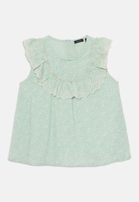 Lys grønn bluse med blomsterprint, blondekant og volangdetaljer rundt halsen, ermeløs design og glidelås bak.
