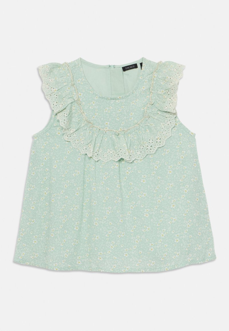 Lys grønn bluse med blomsterprint, blondekant og volangdetaljer rundt halsen, ermeløs design og glidelås bak.