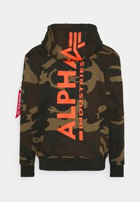 Zöld és barna camo kapucnis pulóver nagy narancssárga "ALPHA INDUSTRIES" logóval. Húzózsinórral ellátott kapucnival és oldalsó zsebbel rendelkezik, piros címkével.