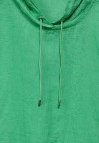 Felpa con cappuccio verde realizzata in tessuto texturizzato, con cordini regolabili e puntalini metallici. Design semplice e minimalista.