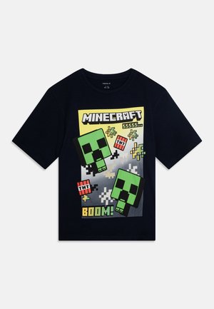 T-shirt en coton bleu marine avec un graphique Minecraft représentant des créatures creeper vertes, des icônes TNT et des éléments pixelisés dans des couleurs vives.