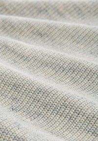 Textielstof met een gestructureerd, geribbeld patroon in lichtbeige en zachte grijstinten, met een geweven, tactiele uitstraling.