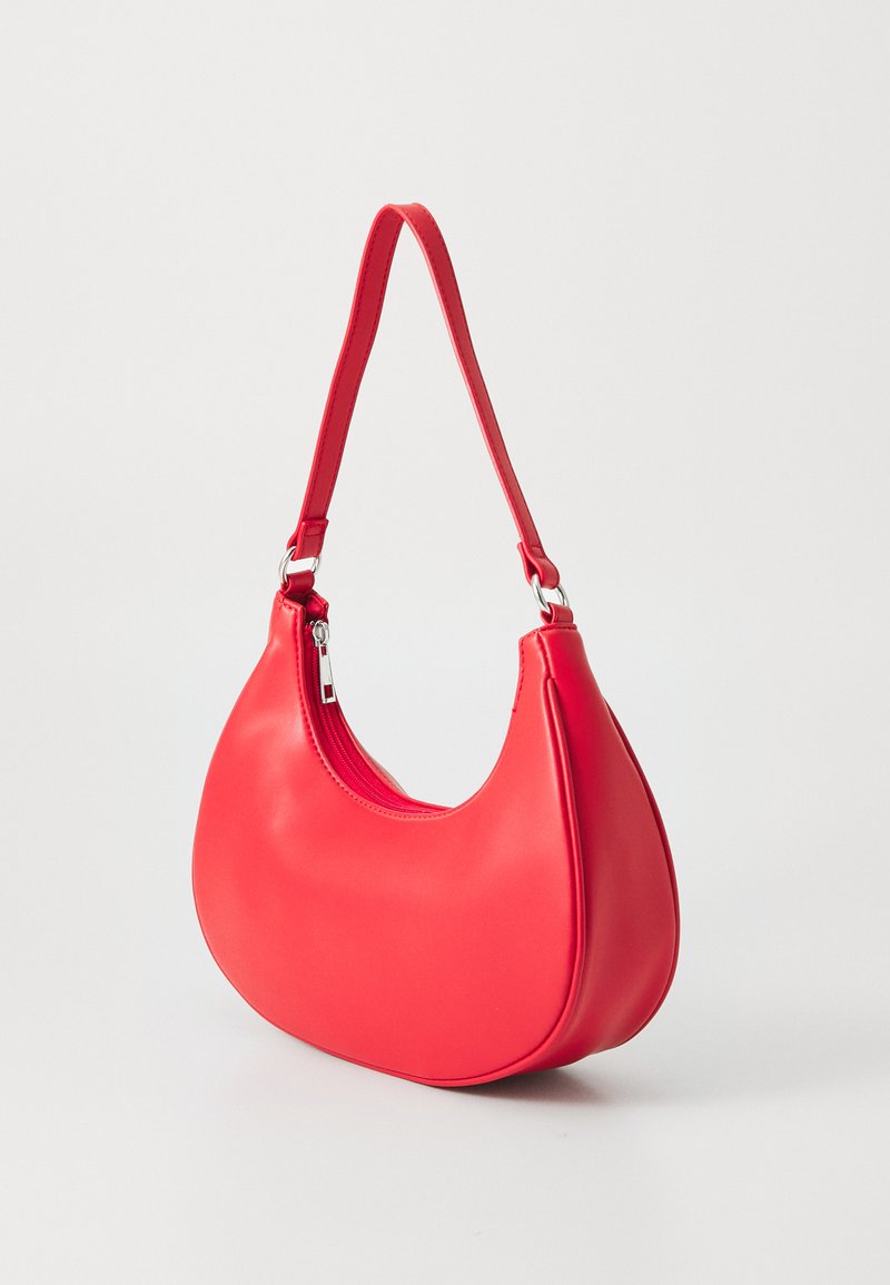 Bolso de mano de imitación de cuero rojo con forma curva, cierre de cremallera y una sola correa ajustable. Textura suave y diseño minimalista.