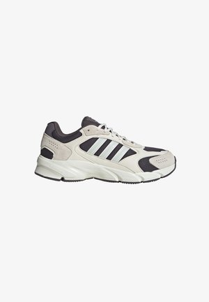 Scarpa da corsa con sovrapposizioni in camoscio beige, pannelli in mesh neri, intersuola bianca e tre strisce bianche sul lato.