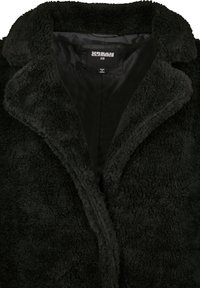 Čierny, jemný, fleece kabát s šálovým golierom a bez zapínania. Interiér je hladký so saténovým povrchom, označený "URBAN CLASSICS XS."