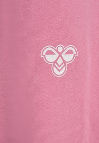 Rosa stickad tyg med ett vitt bi-emblem som design, med en jämn textur och enkel form, centrerad på plagget.