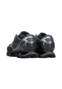 Scarpe da corsa nere con un design elegante, tomaia in rete, colletto imbottito e suola in gomma con grip testurizzato. Accenti riflettenti sul tallone.