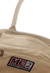 Borsa in tessuto beige con una texture a coste, dotata di chiusura con cerniera, una patch con il logo e un unico manico robusto.