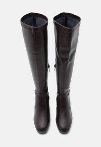 Bottes marron en cuir montantes jusqu'aux genoux avec un design épuré, une texture lisse et une fermeture éclair latérale pour un enfilage facile. Bout arrondi et coutures minimales.
