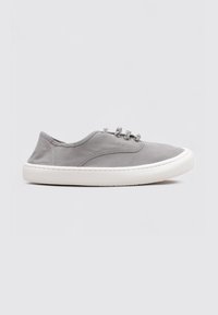 Scarpa slip-on in canvas grigia con lacci elastici, suola in gomma bianca, punta rotonda e dettagli di cucitura minimi. Adatta per un abbigliamento casual.