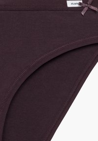 Ciemnofioletowe bawełniane majtki o gładkiej teksturze, z cienką gumką w pasie i małą kokardką z przodu. Widoczne są obszyte krawędzie.