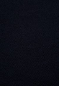 Tissu bleu marine foncé avec une texture lisse, présentant un motif de tricot fin et régulier. La surface semble uniforme sans variations ou accents notables.