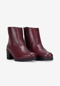 Botas de cuero burdeos hasta el tobillo con un acabado brillante, que presentan un diseño recto, tacón cuadrado y una cremallera lateral para ponérselas fácilmente.