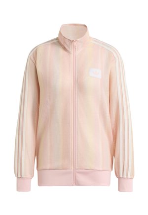Veste rose claire à fermeture éclair intégrale avec texture côtelée, trois bandes blanches sur les manches, poignets et ourlet côtelés, et un petit écusson logo sur la poitrine.