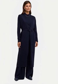 Granatowy długi kardigan wykonany z miękkiego materiału, z długimi rękawami, paskiem w talii i luźnym krojem opadającym aż do kostek.