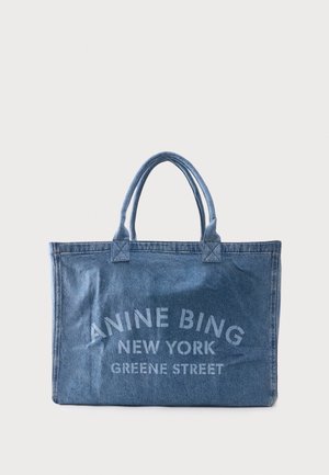 Torba na ramię z denimu z podwójnymi uchwytami, z napisem "ANINE BING NEW YORK GREENE STREET" w jasnoniebieskim kolorze na przedniej stronie.