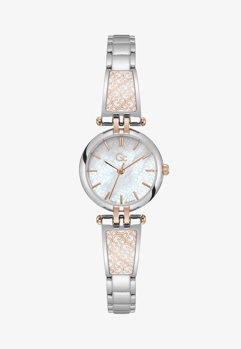 Hõbedane ja roosakuldne kell, millel on ümmargune nägu, tekstuuriga valge kellasett, seotud käevõru rihm keerukate detailidega ning klapitav pandla.