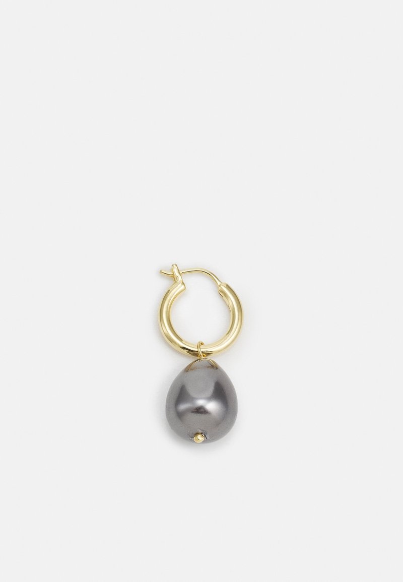 Boucle d'oreille en or en forme de créole avec une grande perle grise en forme de goutte d'eau suspendue sur un fond blanc.
