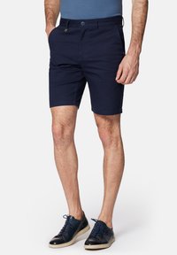 Granatowe szorty wykonane z mieszanki bawełny, charakteryzują się klasycznym krojem, przednimi kieszeniami oraz zapięciem na guzik z małym akcentem logo.