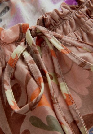 Stoff mit Blumenmuster, überwiegend pink und orange, mit gerafftem Gummibund. Sichtbare Kordelzüge betonen die Textur und Details.