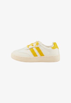 White sneaker with yellow stripes, yellow laces, and yellow heel tab, featuring a beige sole with textured grip.