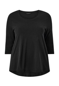 Camiseta negra de manga larga con cuello redondo, hecha de una tela suave, con un corte holgado y un dobladillo ligeramente curvado.