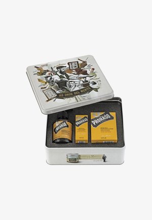Boîte-cadeau en fer blanc avec un design vintage ; contient de l'huile à barbe, du baume et du savon dans un emballage jaune, avec une illustration en noir et blanc sur le couvercle.