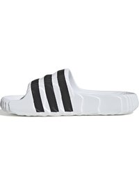 Beli drsni sandal s tremi črnimi črtami, teksturirano zgornji del in podplat, zaobljena oblika in lahka zasnova. Trajni sintetični material.