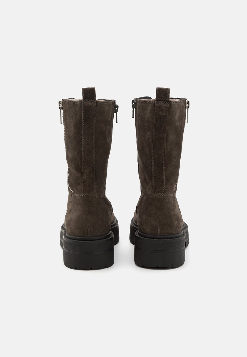 Brązowe zamszowe botki za kostkę o teksturowanym wykończeniu, z czarną gumową podeszwą i bocznymi zamkami błyskawicznymi dla łatwego zakupu. Podwójne języki z tyłu.