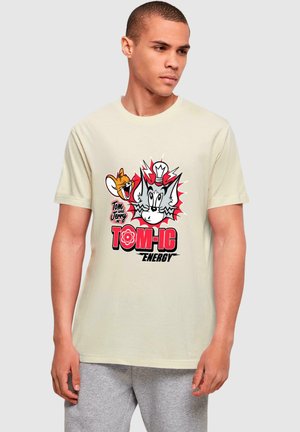 Cremefarbene Baumwoll-T-Shirt mit Cartoongrafiken von Tom und Jerry, mit rotem und schwarzem Text "TOM-IC ENERGY" und kräftigen grafischen Akzenten.