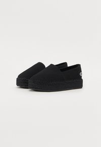 Scarpe espadrillas nere in tela con suola in juta intrecciata, caratterizzate da un discreto logo sulla parte posteriore e una superficie liscia e priva di decorazioni.