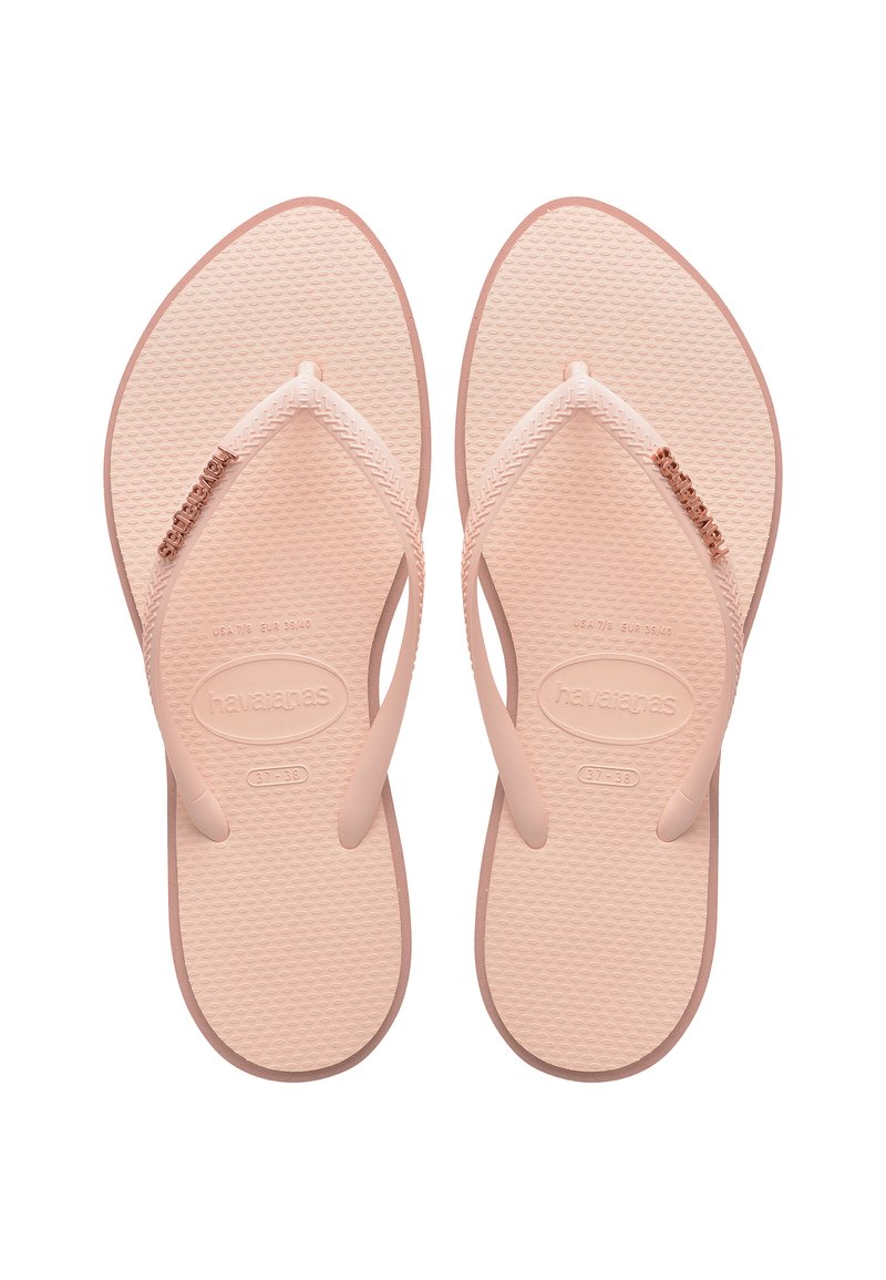 Tan rubber flip-flops with textured soles, thin straps, and a decorative rose gold accent on the left strap. Size indicated as 37-38.