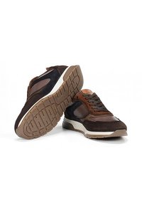 Zapatillas deportivas marrones y negras que presentan una mezcla de materiales de ante y malla, suelas de goma y acentos texturizados. Diseño de cordones con elementos en contraste.