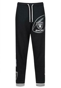 Zwarte sweatpants met witte trekkoorden, voorzien van het Raiders-logo en tekst, en gestreepte boorden bij de enkels. Zacht materiaal, taps toelopende pasvorm.
