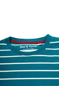 Turkoosi puuvillainen T-paita valkoisilla vaakasuorilla raidoilla, pyöreä pääntie ja punainen sisäkaulus. Sisältää logon etiketin kauluksessa.