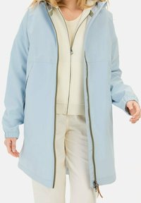 Jasnoniebieska wodoodporna kurtka z kapturem, zamkiem błyskawicznym i elastycznymi mankietami. Charakteryzuje się gładką fakturą oraz regulowanym sznurkiem u dołu.