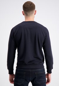 Felpa girocollo navy in morbido tessuto, con maniche lunghe e polsini e orlo a coste. Design semplice senza loghi visibili.