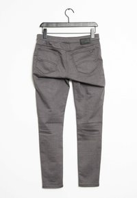 Grijze denim jeans met een slim fit ontwerp. Voorzien van twee achterzakken, een label op de tailleband en een gelijkmatige textuur. De stof lijkt glad.
