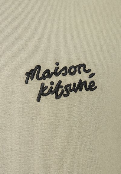 Svetle zelený pulovr s jemnou texturou, vybavený černým vyšitým textem "Maison, kitsuné" umístěným uprostřed přední části.